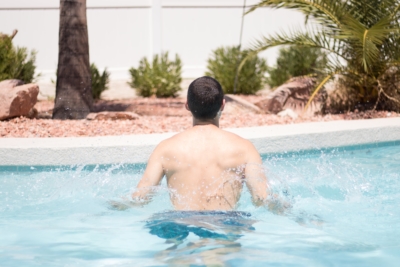 A man doing jumping jacks in a pool.