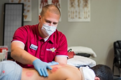 Garrett Johnson doing cupping on a patient