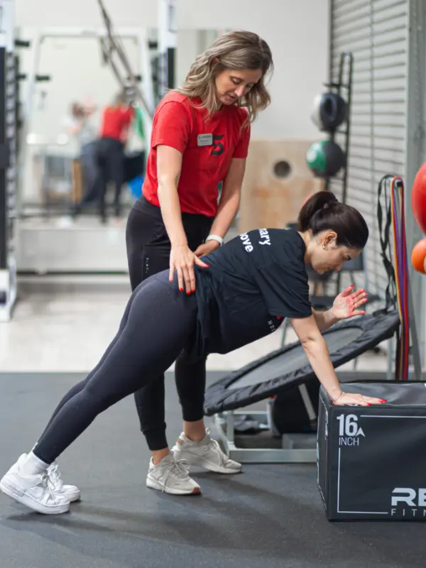 Abby Burger stabilizing the back of a patient as they stretch.