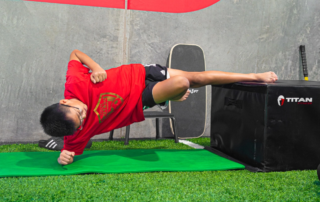 A young boy hold an elevated side plank.