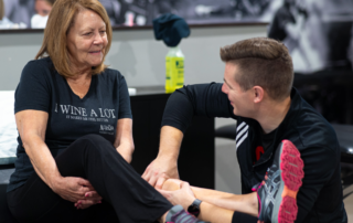 An older woman with arthritis getting checked by a physical therapist.