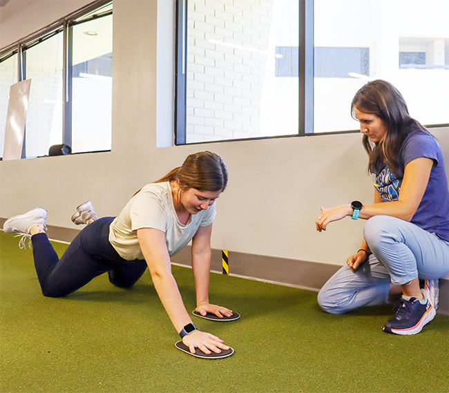 A patient doing floor reaches.