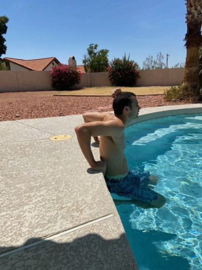 A man doing deck dips in a pool.