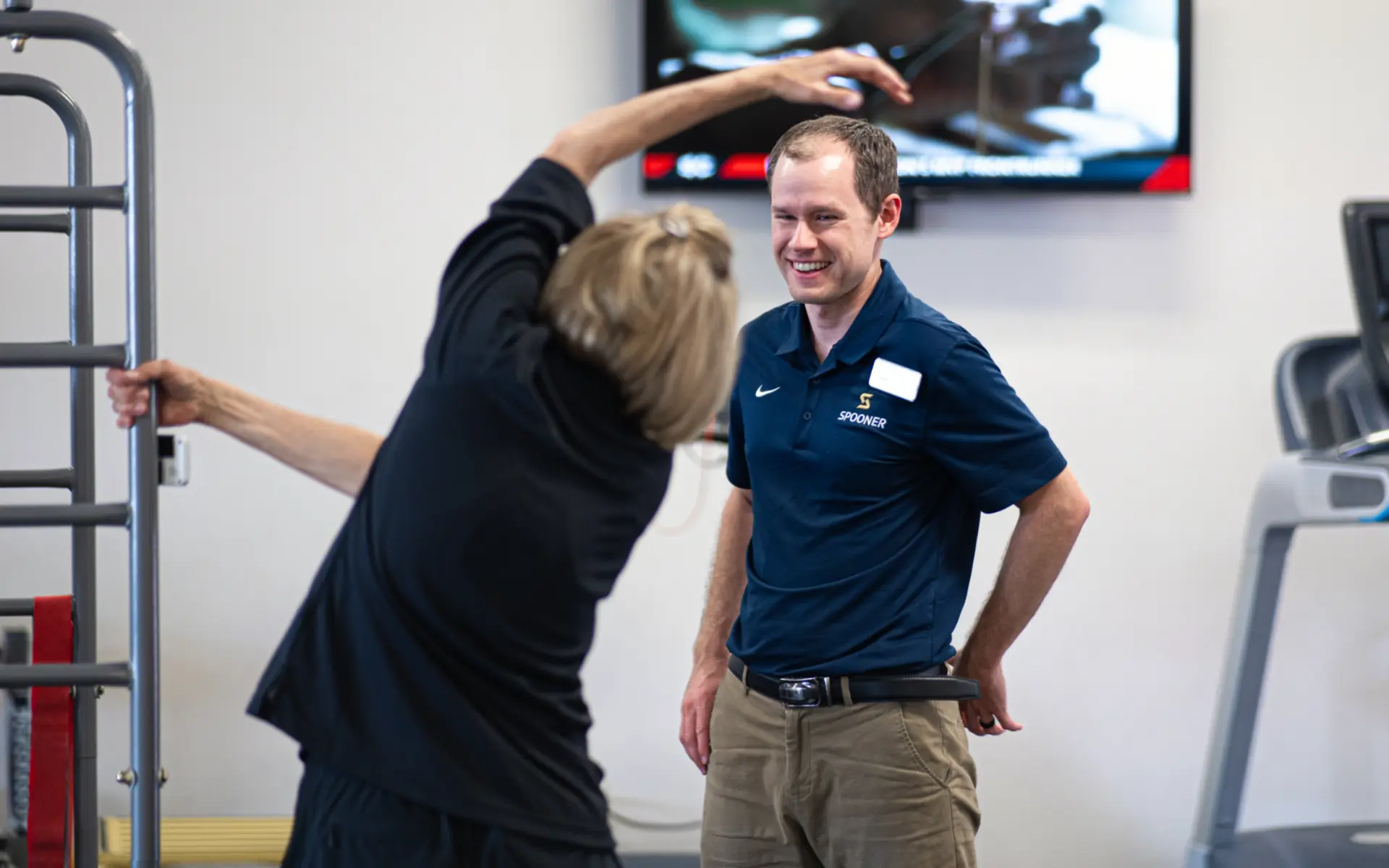 Carson Loose, PT, DPT with an older woman doing over the head stretches at the Spooner Gilbert Clinic.