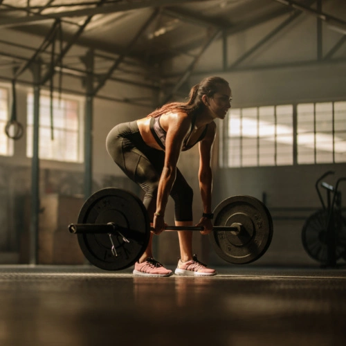 A woman performing a deadlift.