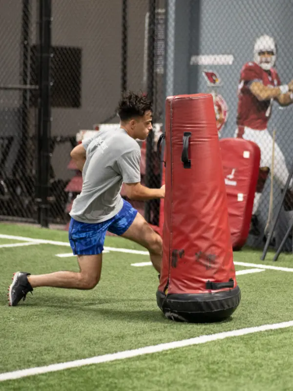 A young athlete runs around an obstacle.