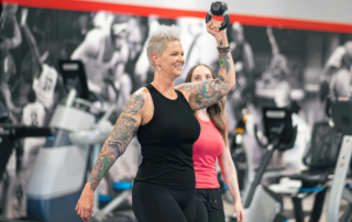 A woman lifting a kettlebell over her head.