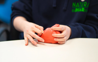 Hands pulling a small metal rod out of a plastic mold.