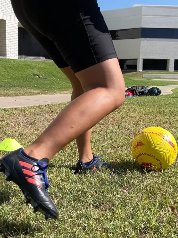 A teenager kicks a soccer ball.