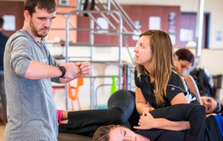 A physical therapy tech working on a patient under the direction of a physical therapist.