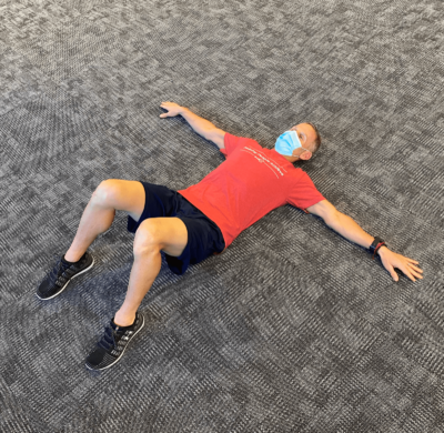 Man doing a T stretch on the floor.