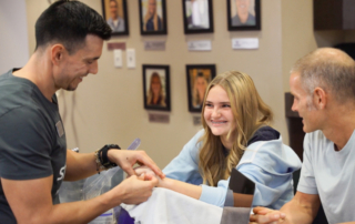 Feature image of a girl receiving hand therapy.