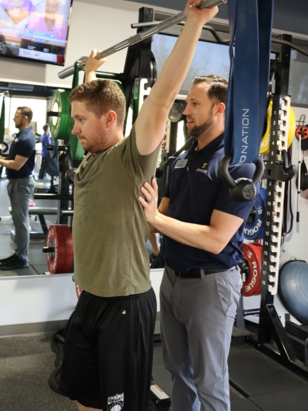 Image of a man holding a barbell over his head.