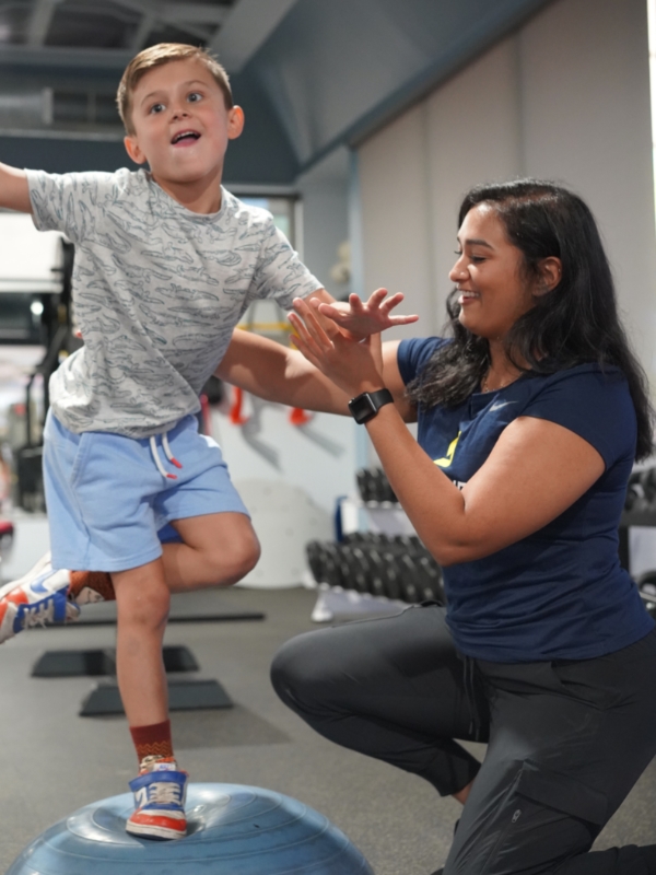 Image of a young child standing on one leg on a 1/2 bosu ball.