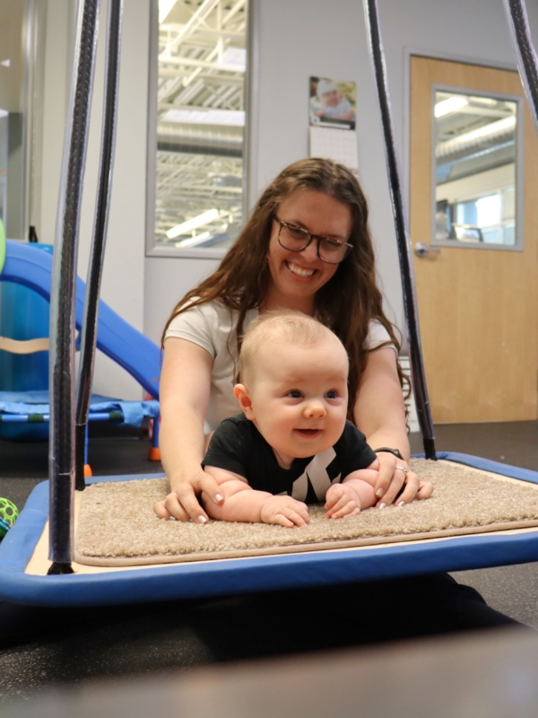 Image of a baby on a tummy swing.